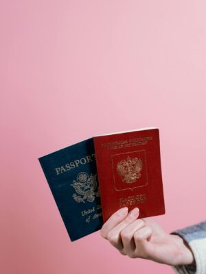 Person Holding Blue and Red Passports